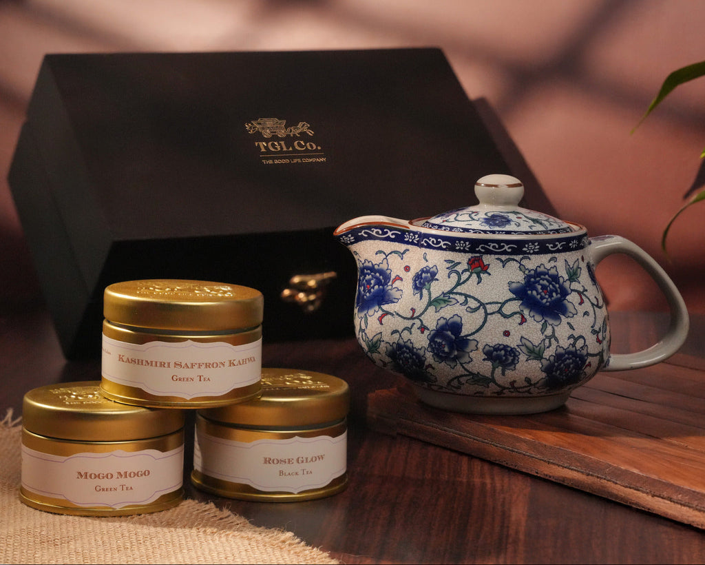 Tea set with teapot and tea tins on a wooden surface, featuring TGL Co. branding.