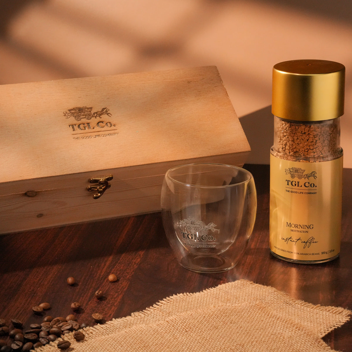 TGL Co. coffee packaging with a glass mug and coffee beans on a wooden surface
