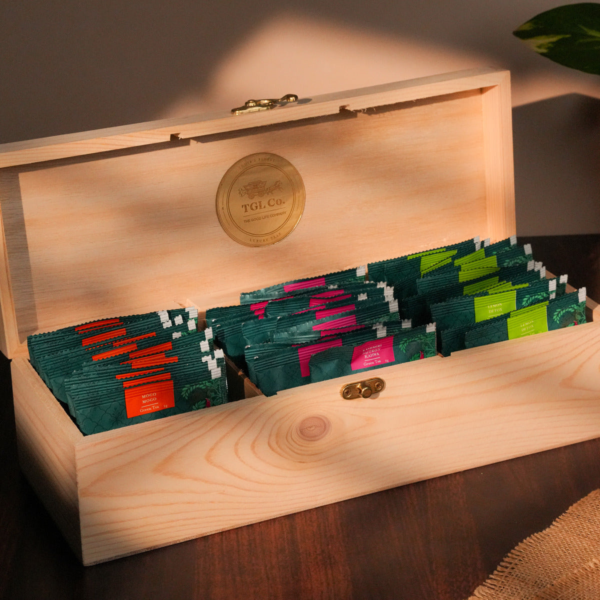 Wooden box with tea bags inside, featuring a visible brand logo.